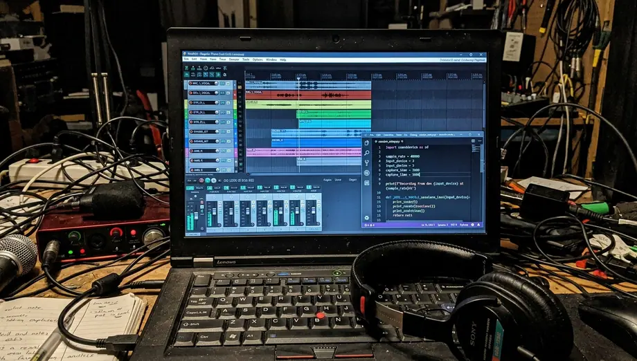 Casual phone laptop screen showing on-site capture digital audio workstation screen session lab code, dark